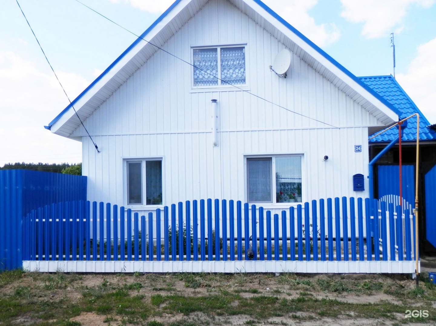 Дом с синей крышей и забором