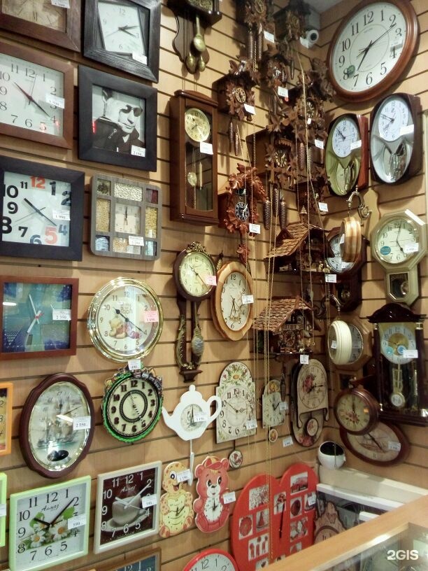 Часы магазины дешево. Магазин настенных часов. Витрина настенных часов. Выкладка часов. Витрина с часами.